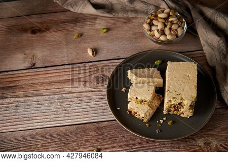 Organic Halva With Pistachios On A Wooden Surface. Traditional Middle Eastern Sweets. Jewish, turkis