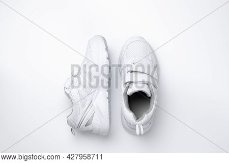 Top View Two White Unisex Sneakers, One Sneaker Is On The Side Isolated On A White Background