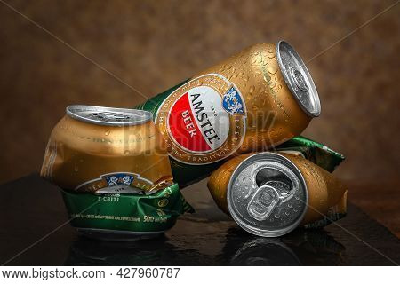 Beer Cans. Wet Crumpled And Full Beer Cans Amstels Drops On Dark Background, Close-up. Amstel Is A W