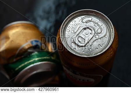 Beer Can. Wet Crumpled And Full Beer Cans Amstel With Drops Of Condensate Water Dark Background, Top