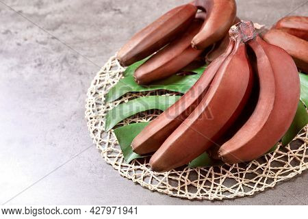 Tasty Red Baby Bananas On Grey Table, Space For Text