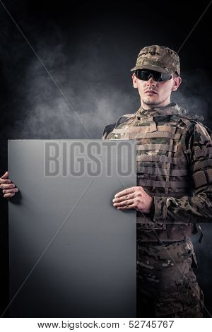 Modern Soldier Is Holding A Poster