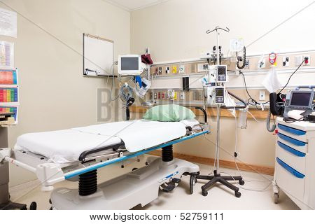 Empty hospital bed with emergency equipment