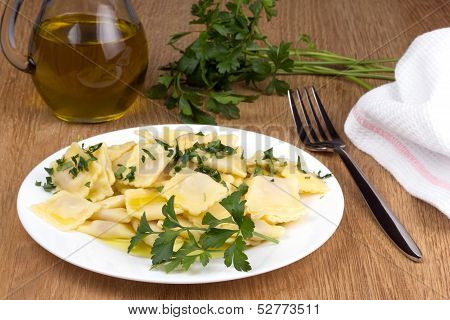 Italian pasta ravioli with parsley olive oil and flatware