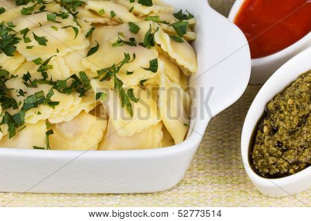 Italian pasta ravioli with parsley pesto sauce and tomato sauce