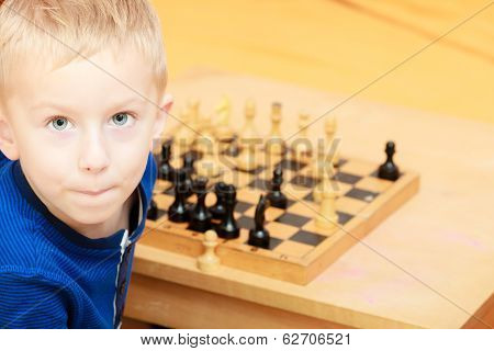 Childhood. Intelligent Boy Child Kid Playing Chess. At Home.