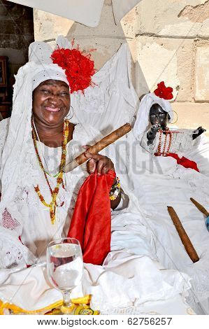 A smiling woman sitting on a bench with a huge cigar