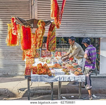 Man Selling Religious Offerings And Decoration At Chawri Bazar In Delhi, India