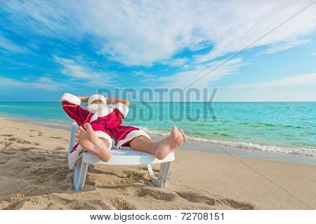 Sunbathing Santa Claus Relaxing In Bedstone On Beach - Christmas Concept