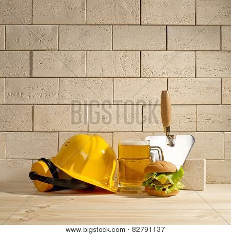 Beer And Burger With The Helmet And Trowel Against A Brick Wall
