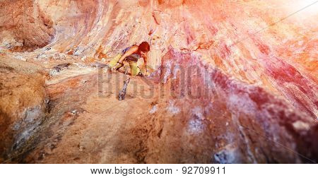 Rock climber climbing up a cliff
