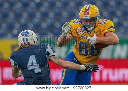 ST. POELTEN, AUSTRIA - JUNE 1, 2014: WR Johan Stal (#86 Sweden) is tackled by DB Pekka Rantala (#4 Finland).