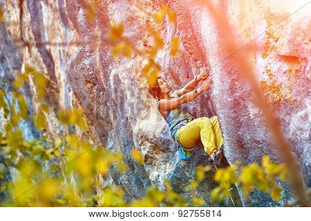 Rock climber climbing up a cliff