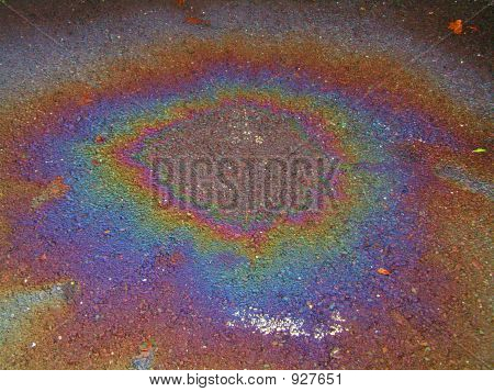 Bunte Ölpest auf Asphalt