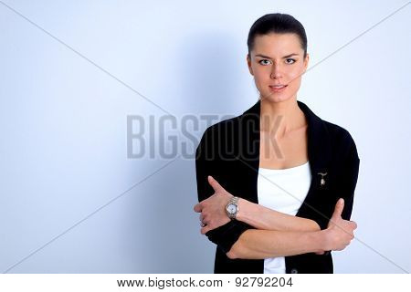 A young woman standing, isolated on graybackground