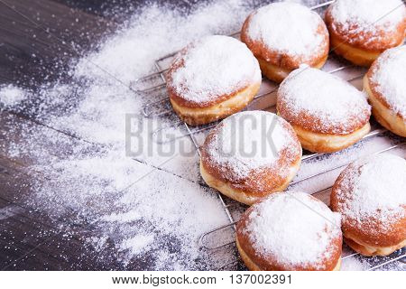 German donuts - berliner with icing sugar on a dark wooden background