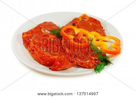 Raw meat. Pork escalope slices with sause  in a Dish Isolated Against White Background