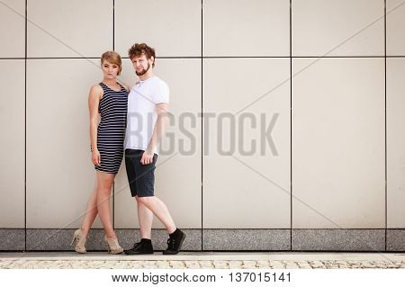 Sexy sensual couple posing outdoor. Pretty stunning woman in striped dress and handsome man in white shirt. Love and date concept.
