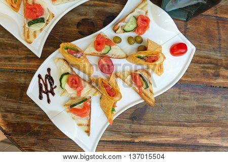 Beautifully decorated catering banquet table, one dishes on a wooden table.