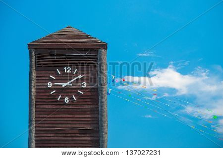 Clock tower made of wood on blue sky background