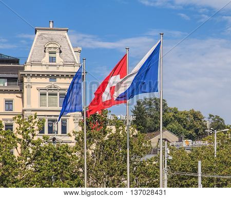 Zurich Switzerland - 2 August 2014: flags of Zurich and Switzerland on the Quaibruecke bridge. Zurich is the largest city in Switzerland and the capital of the Swiss canton of Zurich.