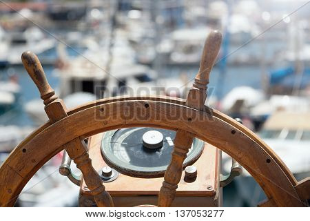 Captains steering wheel of an old wooden sailing ship in a port