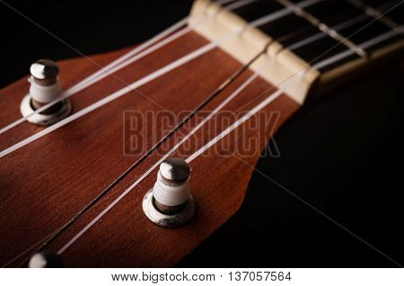 a ukulele on black background. Close up