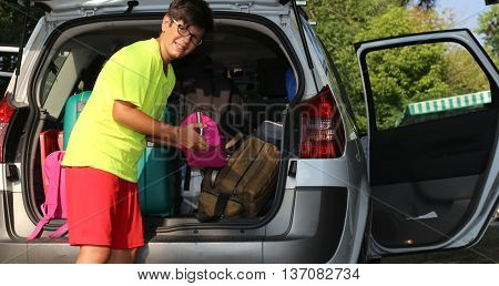 Young Boy With Glasses Loaded The Luggage In The Trunk