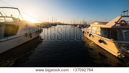 boats in Alghero harbor at sunset Sardinia