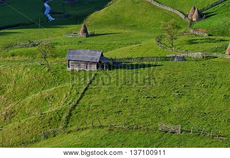 Small old cottage in the green meadow