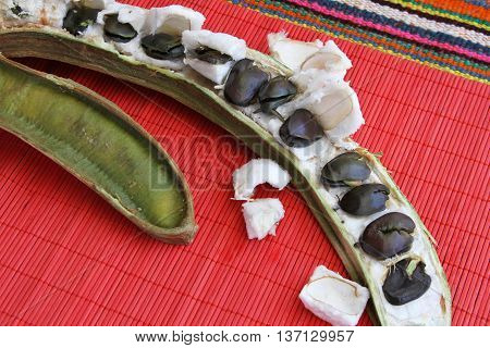 Sliced pacay pod with seeds on colorful place mat