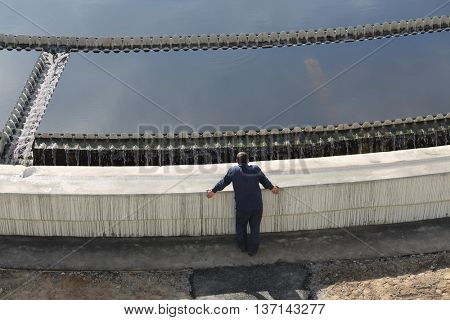 Biological wastewater treatment is carried out in aeration tanks of propellant, worker stands near primary settler