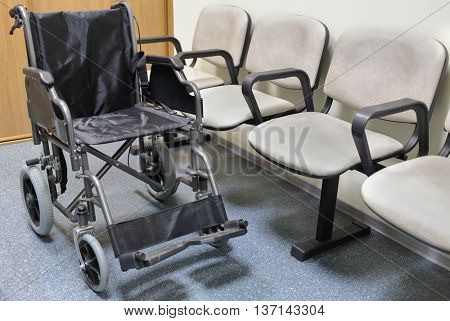 Wheel chair stands in lobby of hospital ready to transport patient