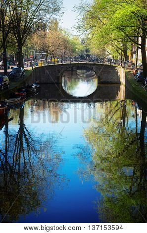 Bridge over canal with mirror reflections, Amstardam, Netherlands, toned
