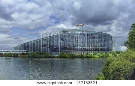 Back of European Parliament building in Strabourg and Ill river by cloudy day, France