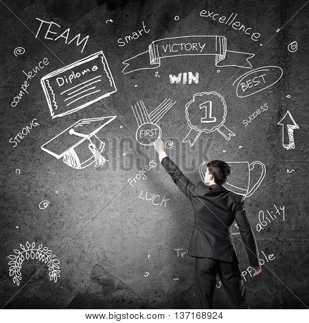Rear view of man drawing education concept on blackboard with chalk