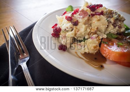Potato salad on bed of spinach greens with dried cranberries