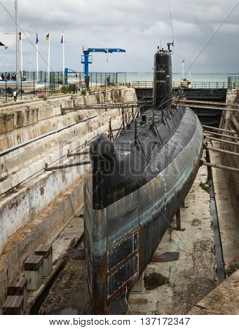 shipyard in the port with old rusty submarine under repair