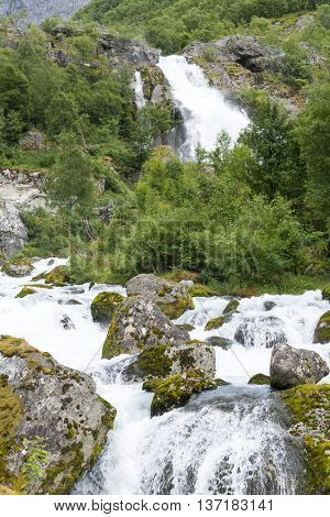 Mountain river from melted ice of Briksdalsbreen glacier at summer. Jostedalsbreen National Park in Norway.