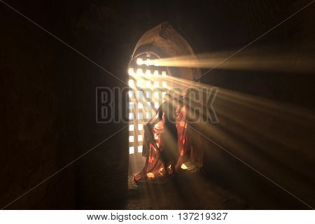 Novices are dressed with light shining through a window in the pagoda.