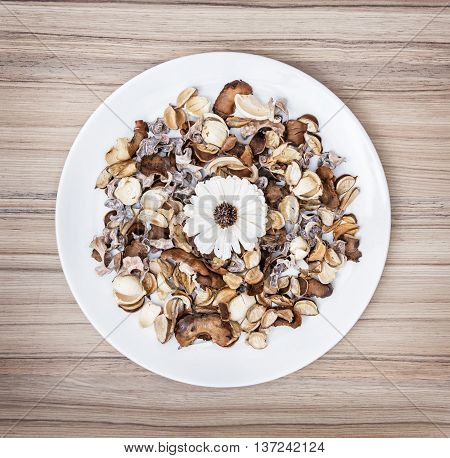 Decoration of dried flowers on the white plate. Natural beauty. Spa theme. Potpourri scene.