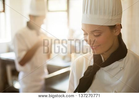 Happy head chef cooking at stove in a commercial kitchen