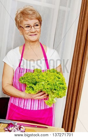 Senior woman tearing green lettuce