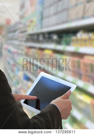 Businessman checking inventory in market on tablet computer