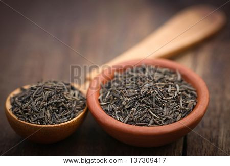 Caraway seeds in a wooden spoon and bowl