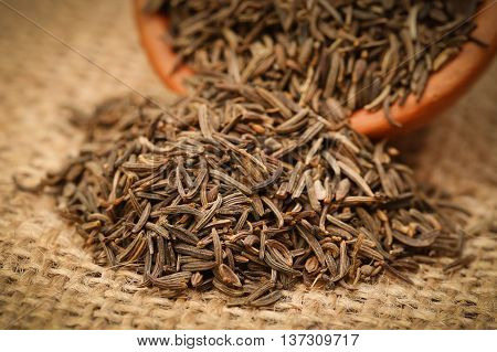 Caraway seeds in a bowl on jute