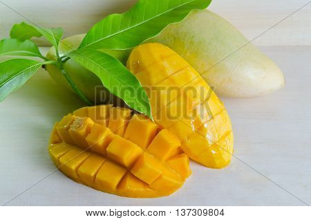Mango ripe with nicely cut pieces and leaf on wooden board (Other names are horse mango Mangifera foetida Anacardiaceae Mangifera M. indica)