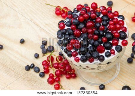 Dessert with cream and fresh berries (red and black currants, blueberry)