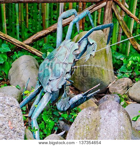 metal sculpture crabs partially oxidized sprays water to passers-by a forest of bamboo canes