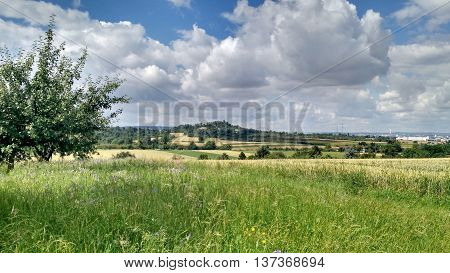 Over the hill and far away, under a summer cloudy blue sky.